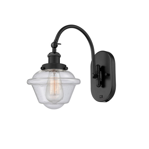 Innovations Oxford 8in 1-Light Swing Arm Wall Sconce | Industrial Matte Black Steel and Seedy Glass | Bedroom Reading Light | Model 918-1W-BK-G534